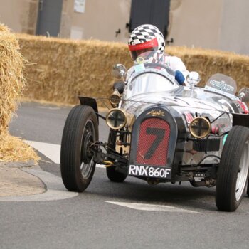 Voiture rétro sur un circuit fermé entouré de ballots de paille 