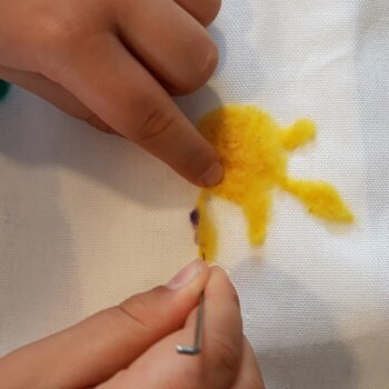 Laine jaune feutrée sur une pièce de feutre.