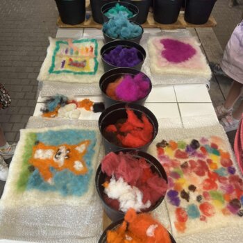 Photographie de pièces de feutre colorés accompagnée de pots avec de la laine colorée. 