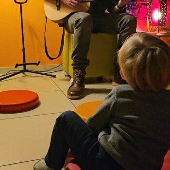 Plan sur un homme jouant de la guitare à un enfant 