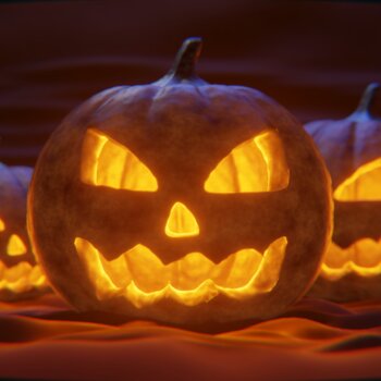 Trois citrouilles d'Halloween sculptées avec des visages effrayants et illuminées de l'intérieur.