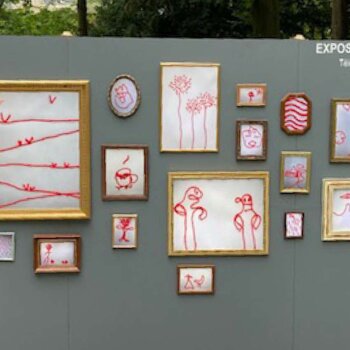 exposition de différents tableaux accrochés à un mur destinés aux enfants 