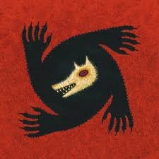 Image de la boite de jeu de société "Loups-Garous de Thiercelieux" composée d'un fond rouge et d'un loup noir et beige réalisé de manière abstraite. 