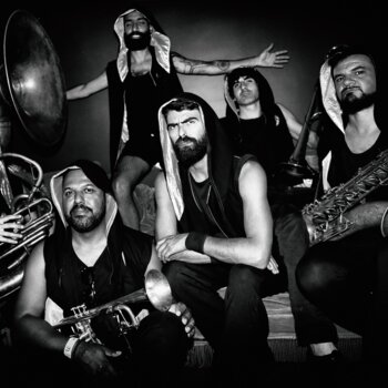 Photographie en noir et blanc du groupe TechnoBrass accompagné de leurs instruments