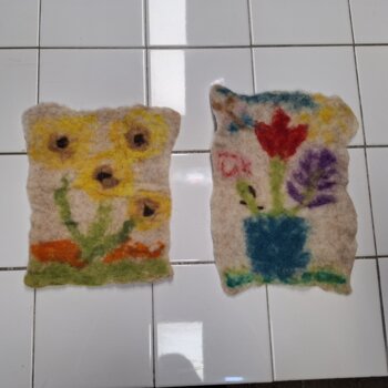 Pièces de feutre composées de fleurs colorées à l'aide du feutrage à l'aiguille.